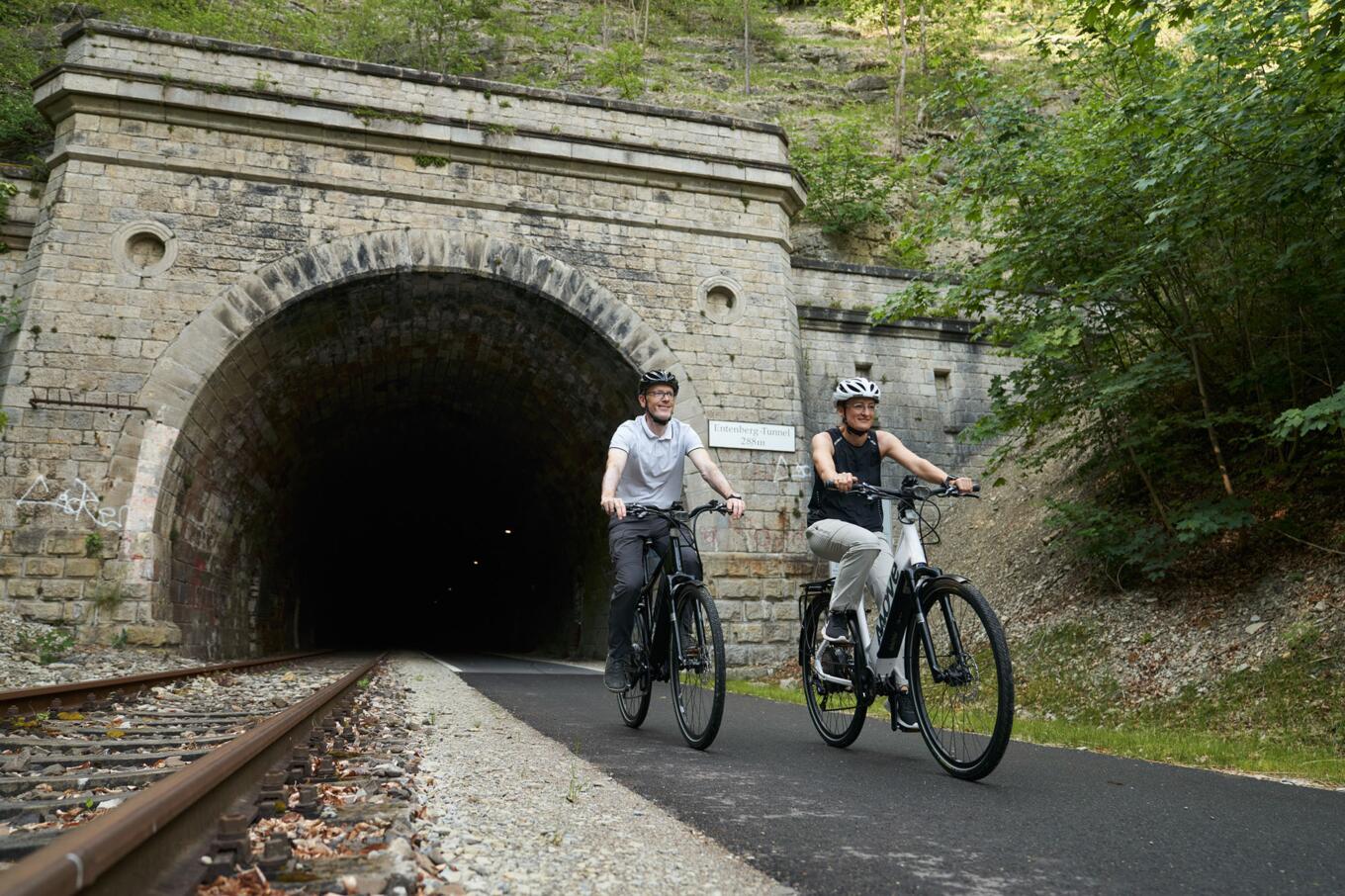 Radfahrer kommen aus einem Tunnel auf dem Kanonenbahnradweg